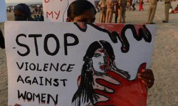 Young woman holding sign that says 'stop violence against women'
